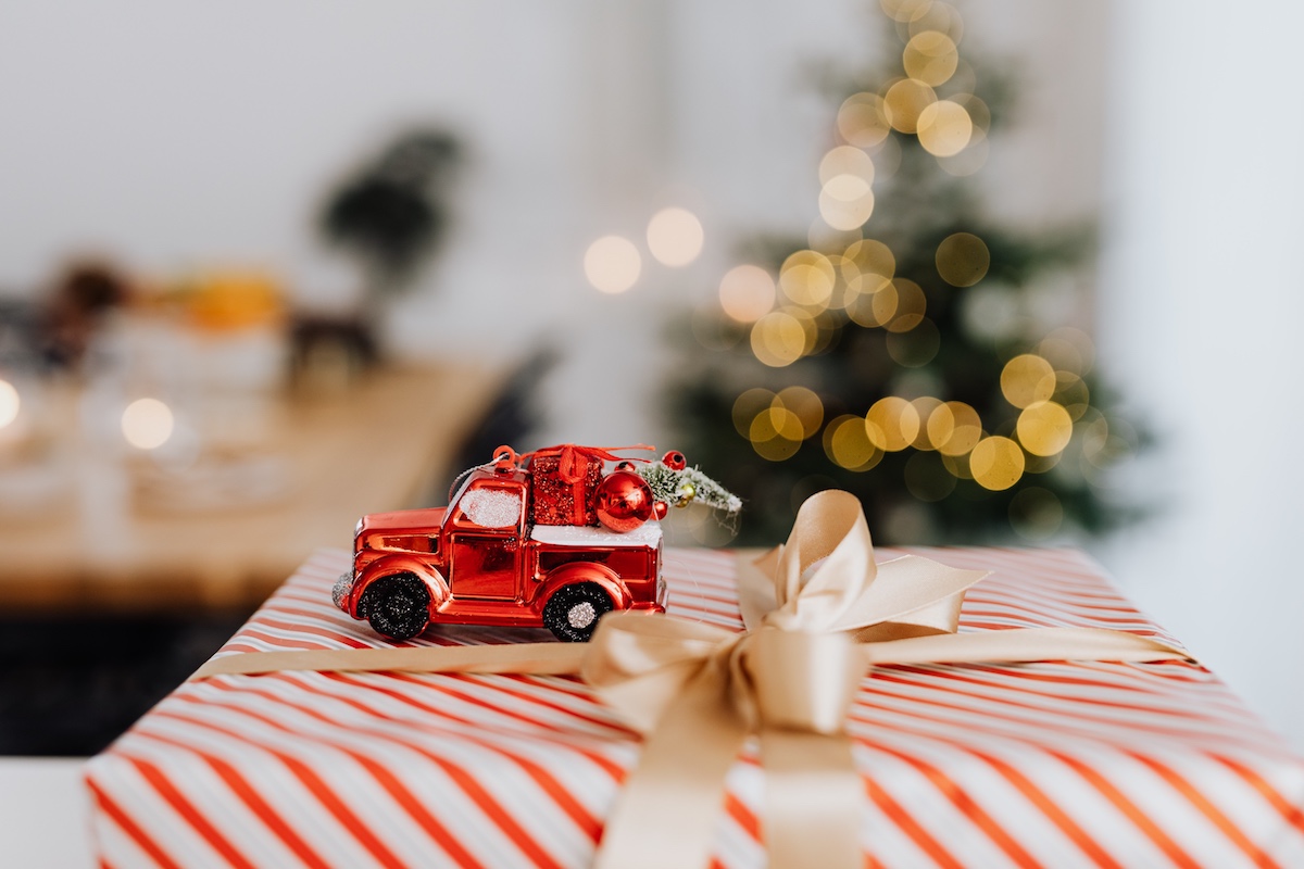 A toy Santa car on top of a present. 