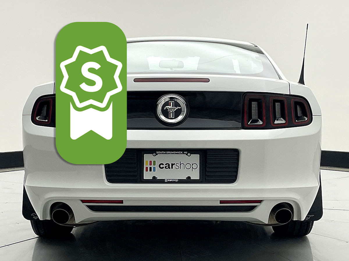Rear view of a white Mustang from CarShop with a Select badge overlaid. 