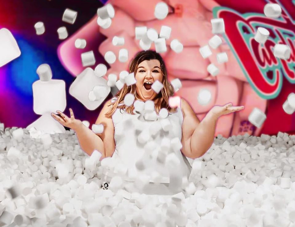 A woman in a pool of marshmallows. 