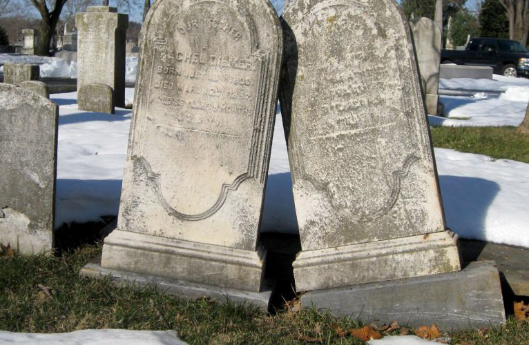 Two tombstones leaning on each other. 