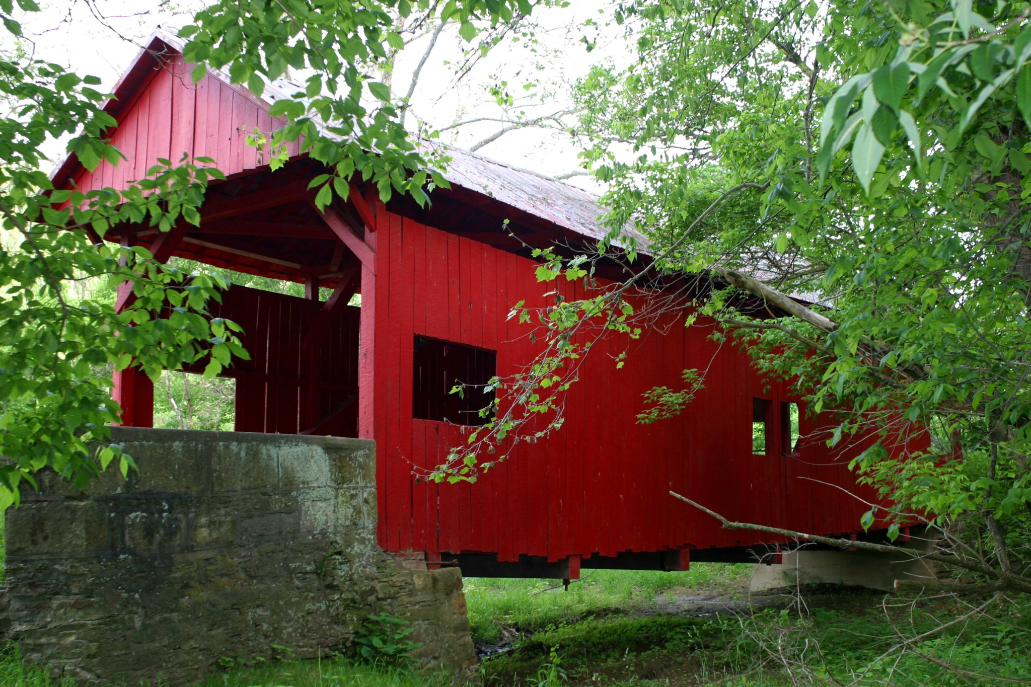 A covered bridge surrounded by trees. 