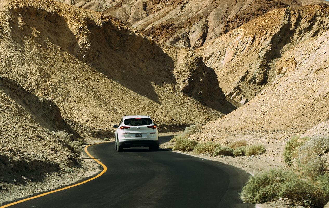 Car driving through the desert.